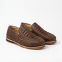 Pair of brown woven leather huarache slip-on shoes on a white background.